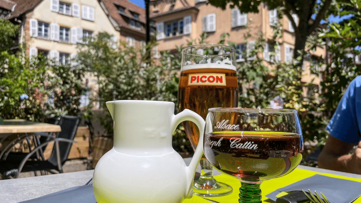 A beer, wine, and table are in the picture in Colmar's center