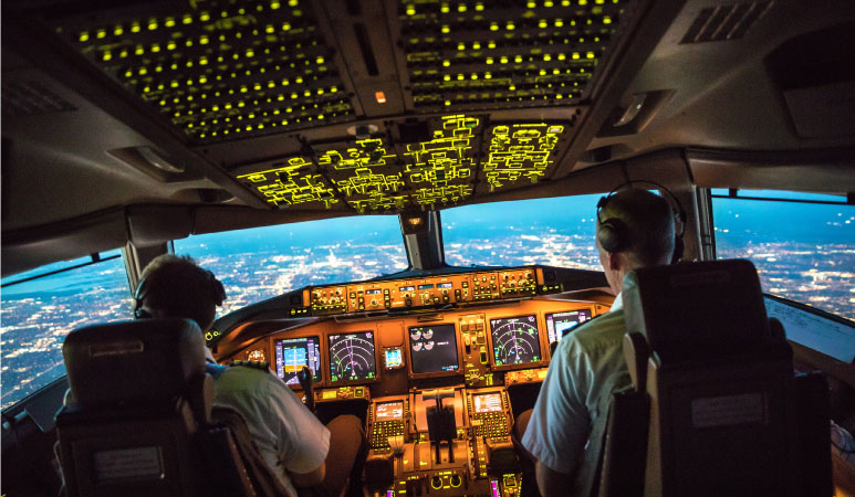 Pilots at work in the cockpit of a commercial airplane during departure from Dallas-Fort Worth International Airport.