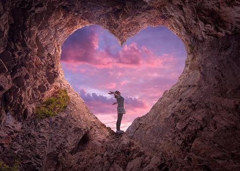 Young Woman In Heart Shape Cave Towards The Beautiful Sky Stock Photo -  Download Image Now - iStock