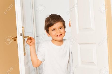 Niño Sonriente Niño Abriendo La Puerta Blanca En Casa Fotos ...