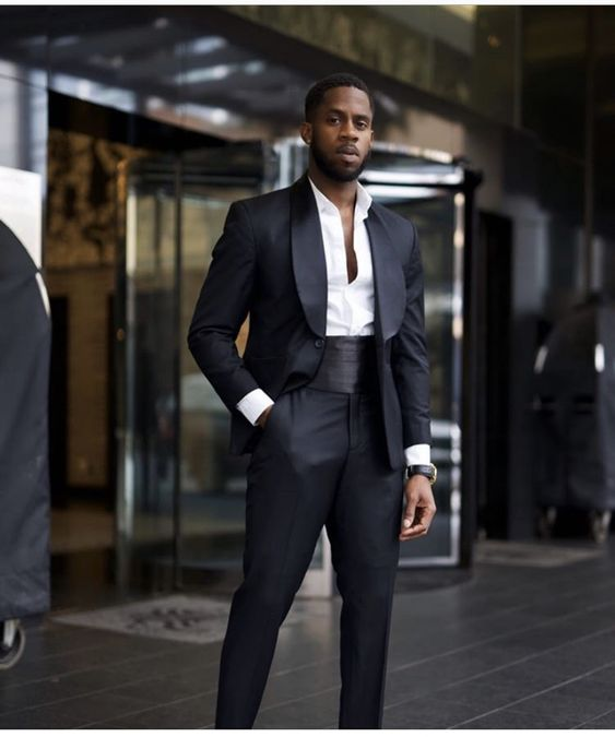 a man wearing a nice tux with a cummerbund as a prom outfit for men