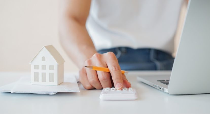 A woman is using a calculator to figure out her budget according to her new cost of living. She is moving from Texas to California.