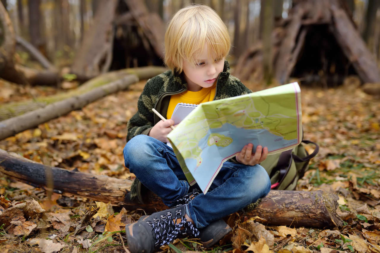 A child reading a map, one of the unplugged activities that benefit from these coding basics
