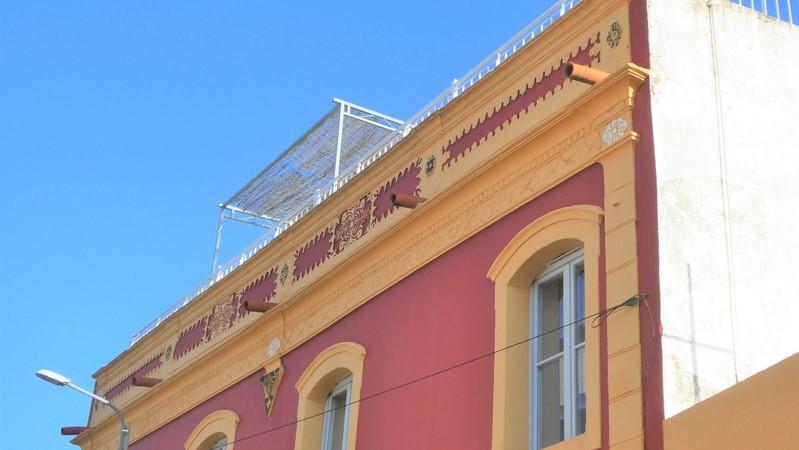 Dachleiste eines renovierten, rot/gelb gestrichenen Hauses im Zentrum von Moncarapacho