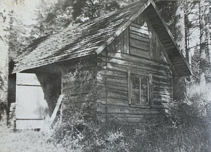 An old barn in front of a houseDescription automatically generated