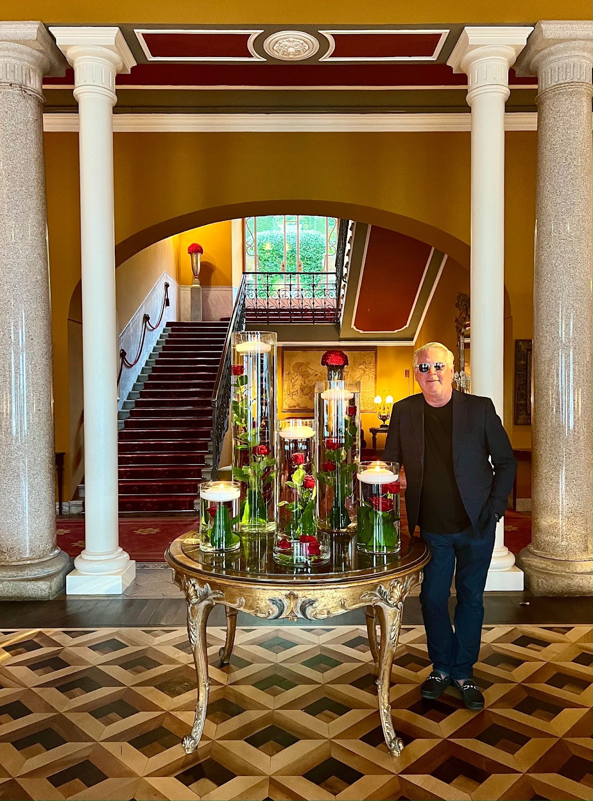 a man standing next to a table with flowers