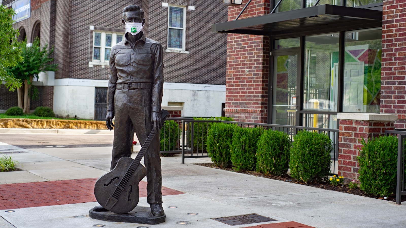 A bronze statue of Johnny Cash with an MCIL surgical mask