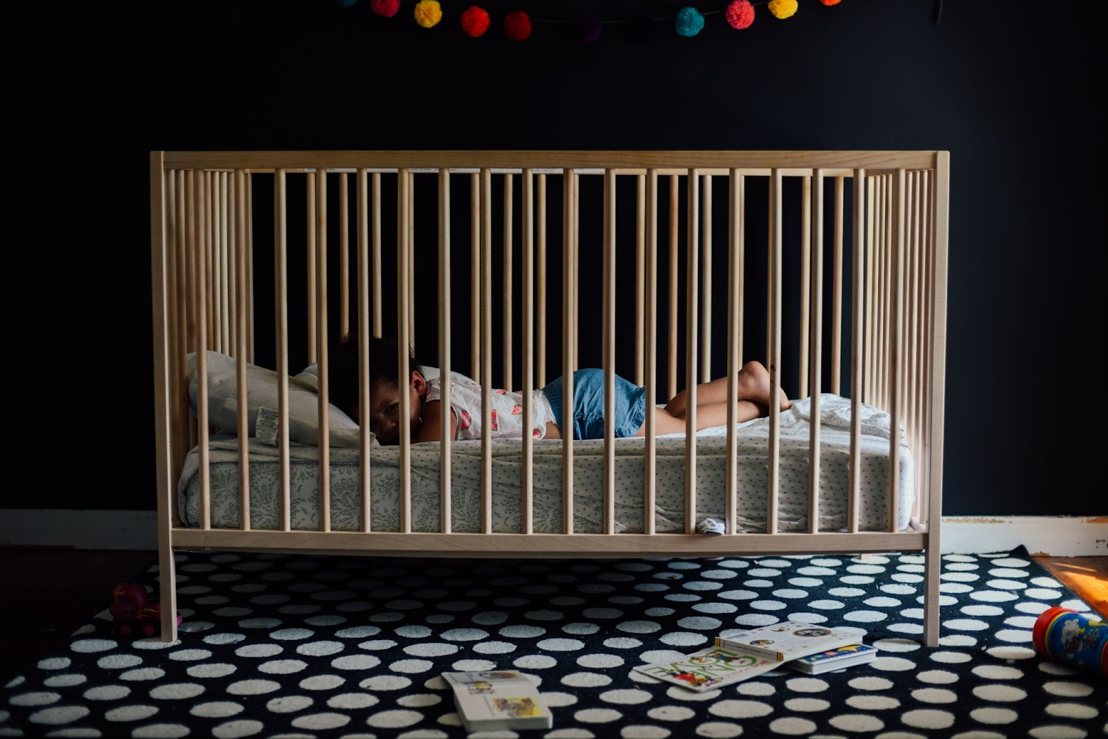 Toddler sleeping in a crib -Toddler bedroom ideas featured image - Baby Journey