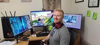 A person sitting at a desk with multiple computer screens

Description automatically generated with medium confidence