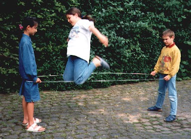La niña no solamente puede saltar la cuerda sino que también puede saltar muy alto
