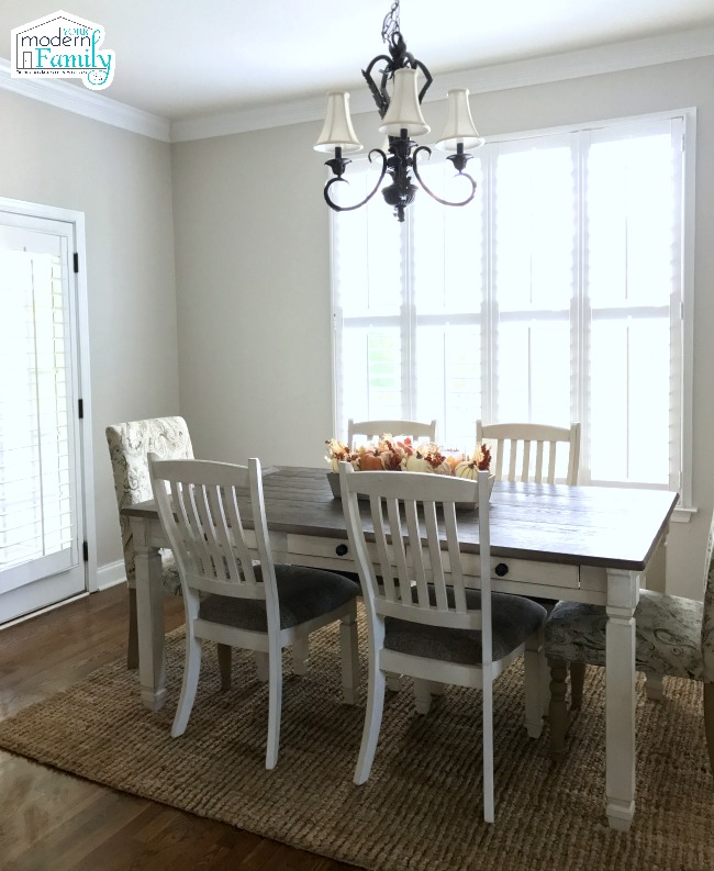 A dining room table in front of a window.