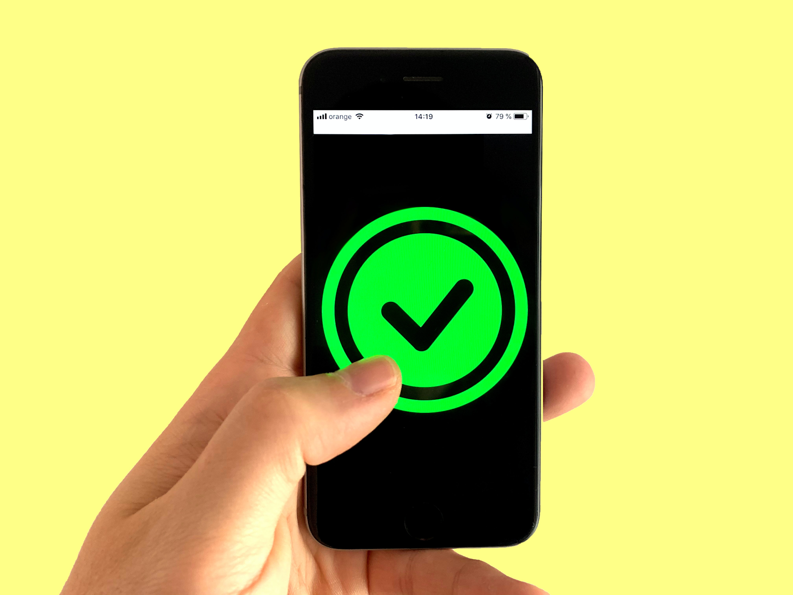 a hand holding a cell phone with a green check mark on the screen