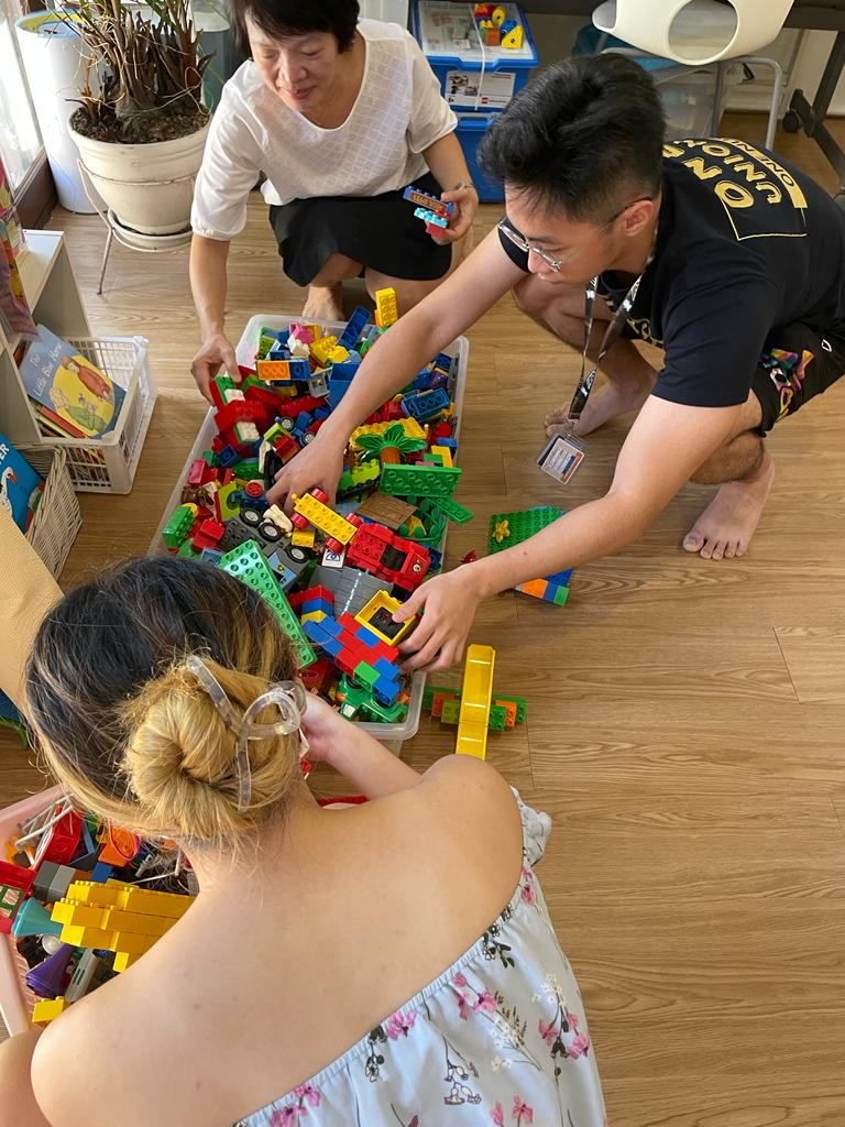 Adults Playing With Lego Pieces