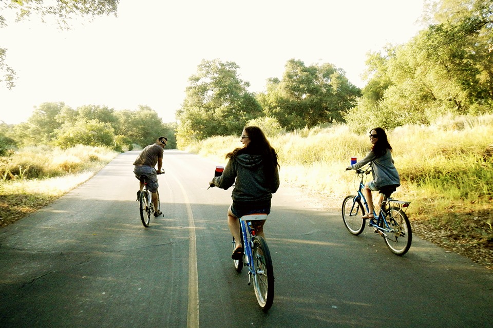 three happy girls bike down the road on an RV trip in Chilliwack