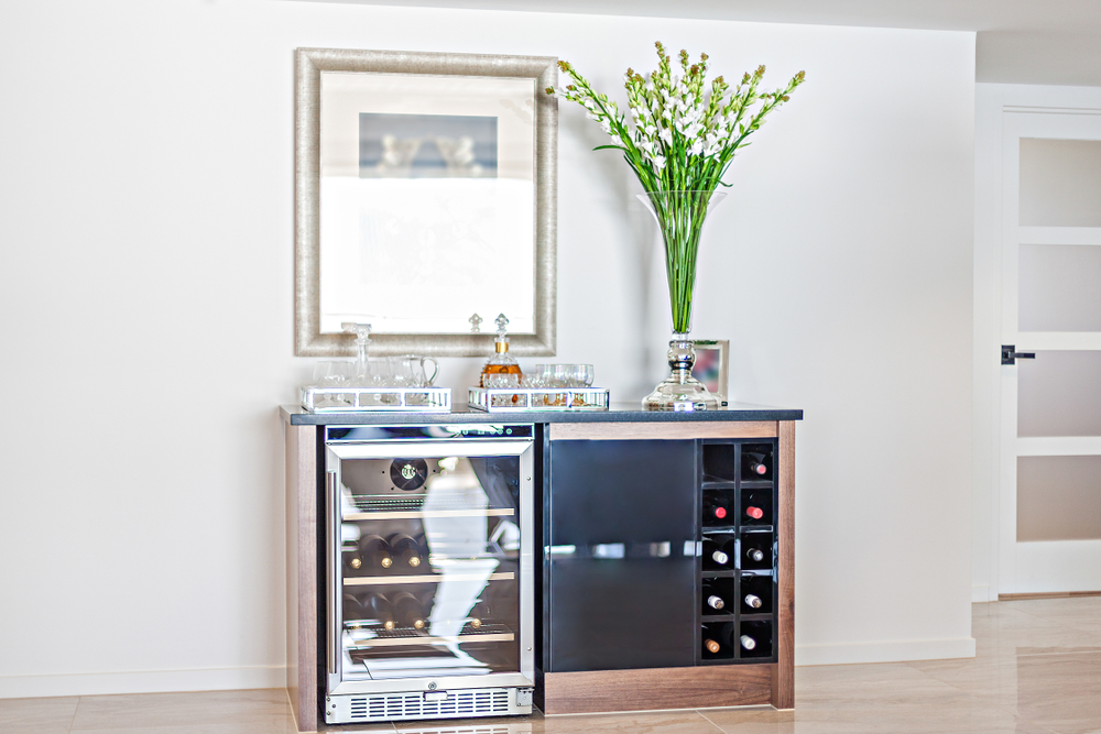 Photo of wine refrigerator next to wine rack