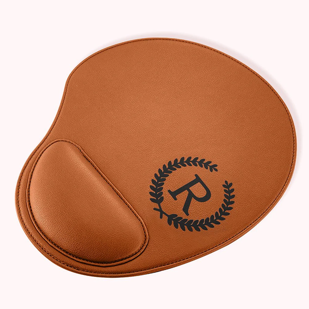 tapis de souris marron en cuir, avec personnalisation par une initiale entourée de feuilles d’olivier.