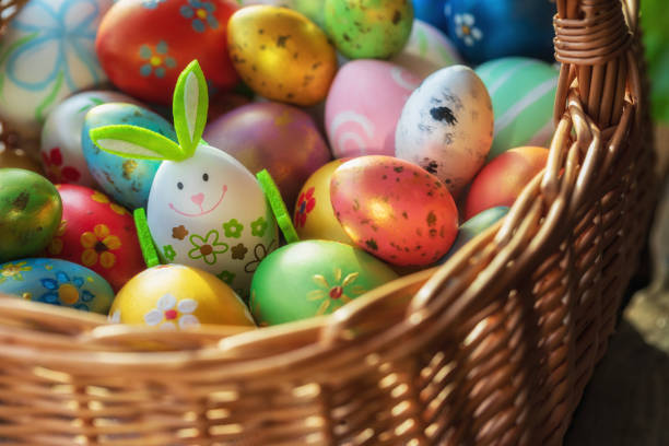 Decoración de Pascua con conejito de Pascua hecho a mano y huevos en la cesta de mimbre. Composición de Pascua de primavera. - foto de stock