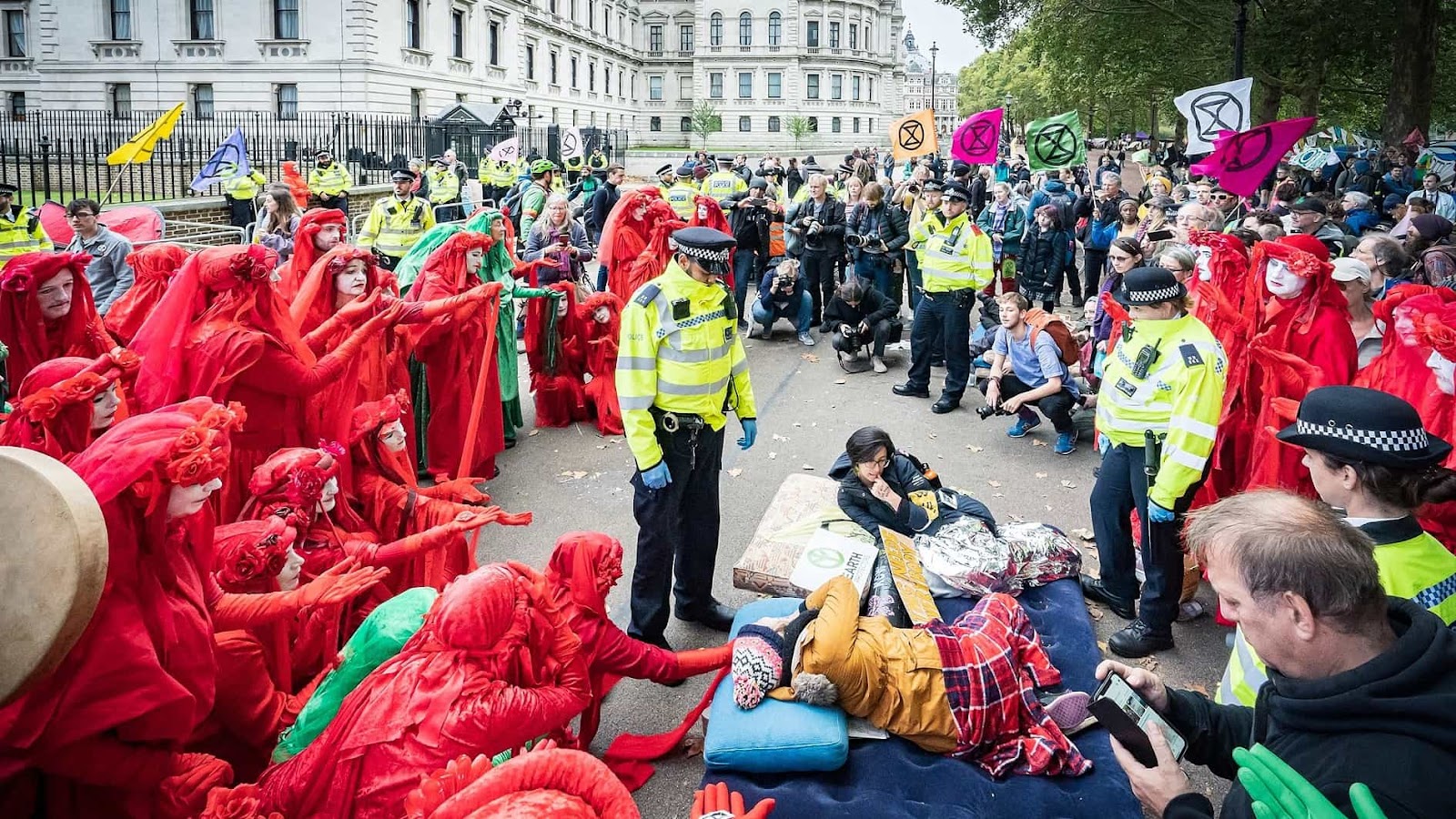 Red rebels surround police during a former UK rebellion.