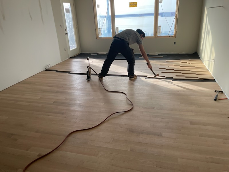 home building technician adding hardwood floors for a home remodel