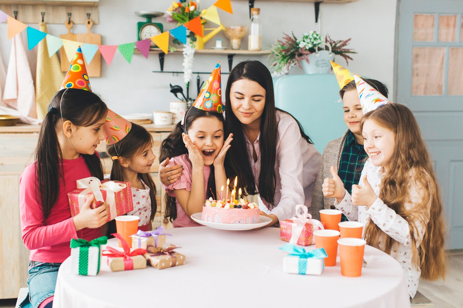 A young girl celebrating birthday with her mother and friends.