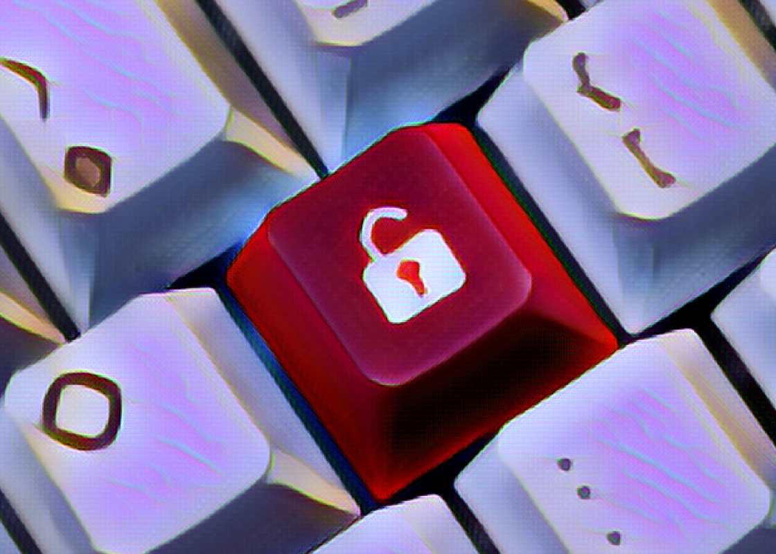 A red computer hot key with an unlocked lock is surrounded by regular keys- close-up. 