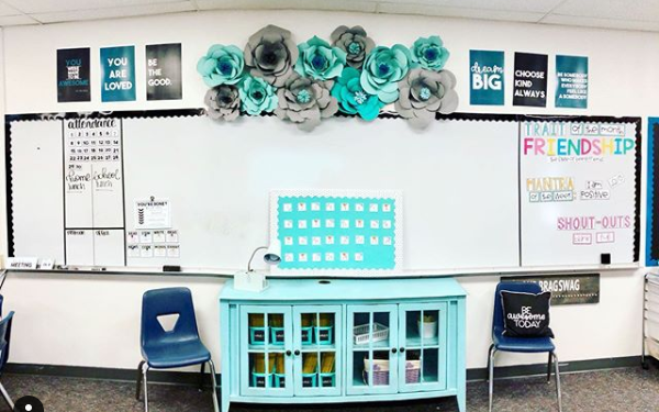 photo of a classroom dry erase board, 2 chairs, motivational posters, and cabinet all in monochromatic blue-gray color scheme