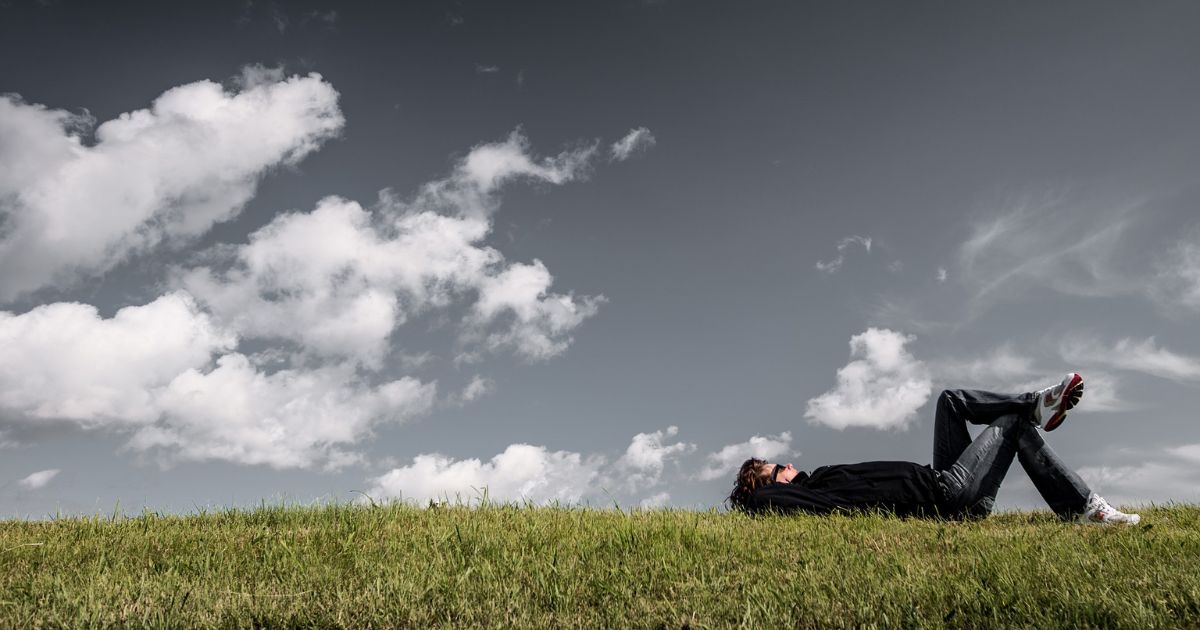 草原ね寝そべっている男性
