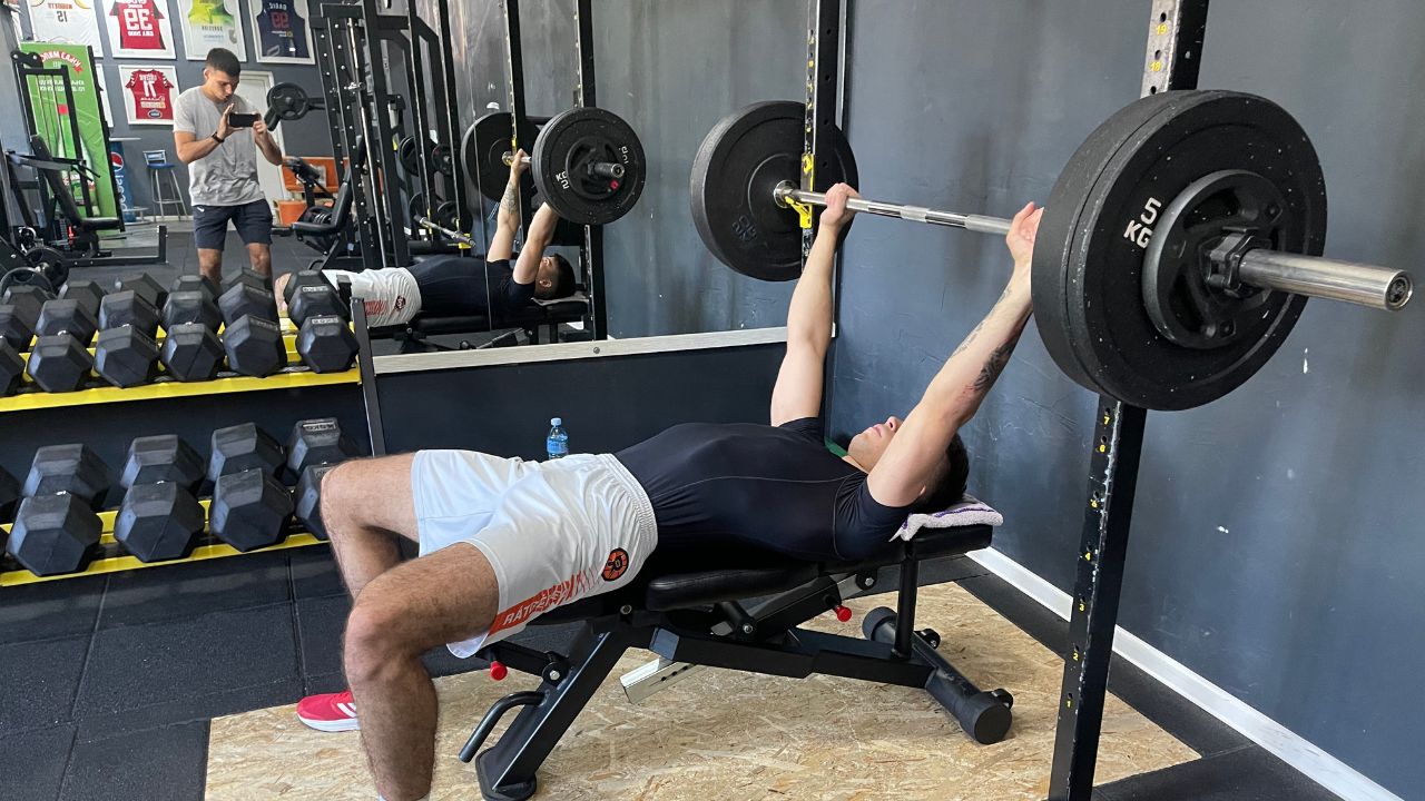 Vanja performs a barbell bench press exercise.