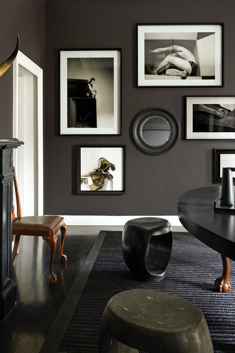 Sophisticated living room with dark walls, black and white art gallery, and wooden accents.