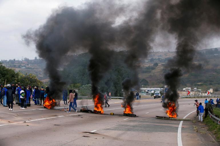 Supporters of former South African President Jacob Zuma block the highway with burning tyres during a protest in Peacevale, South Africa. [Rogan Ward/Reuters]