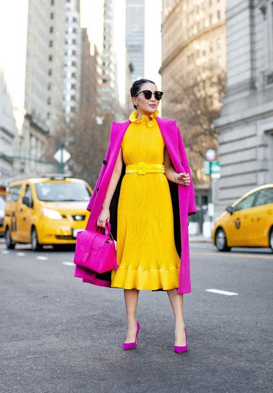 A lady wearing a yellow dress with a pink coat and pink shoes for women