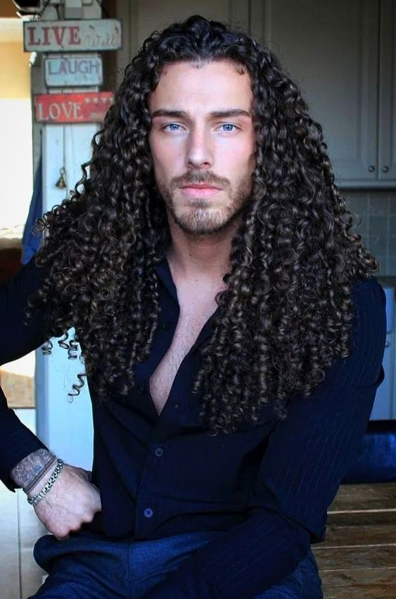 A gorgeous white man with long curly hair