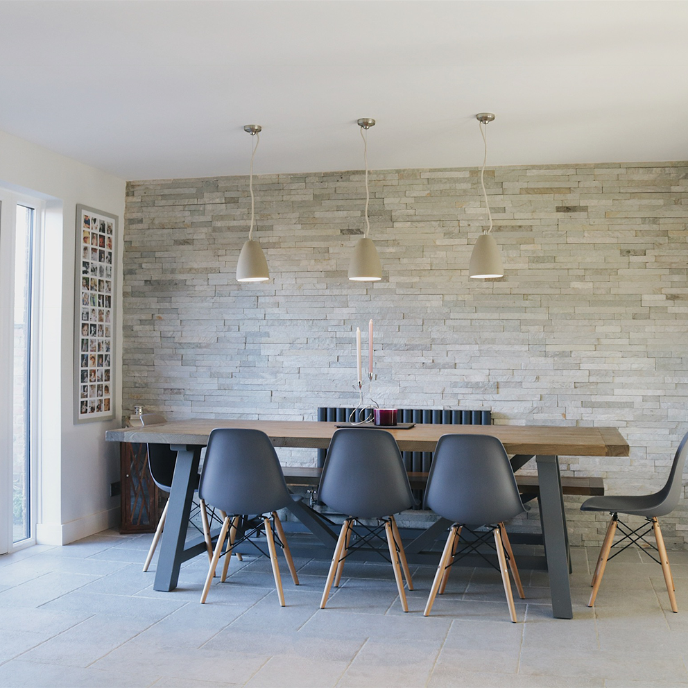 Ivory split face mosaic tiles as a feature wall in a relaxed dining room space