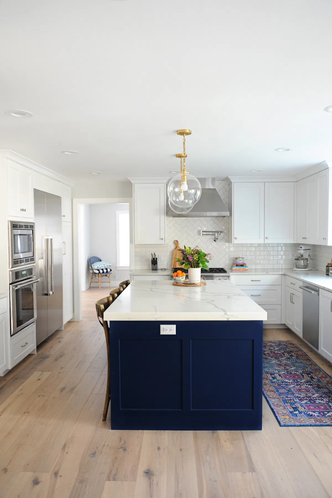 contemporary blue and white kitchen design with white shaker cabinets and a navy blue center island. blue and white cabinets are one of the best cabinet colors for 2020