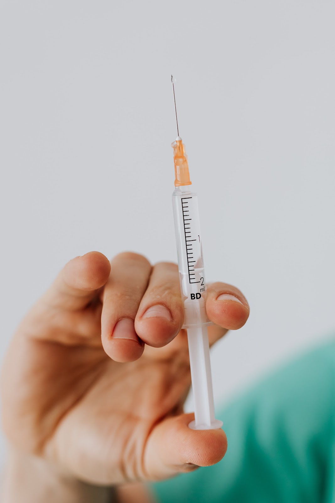 A close-up view of a person holding a vaccine.