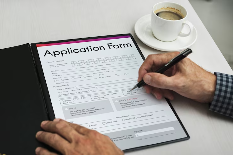 A close-up image of a pen hovering over a medical school application form, with various sections and fields to be filled out.