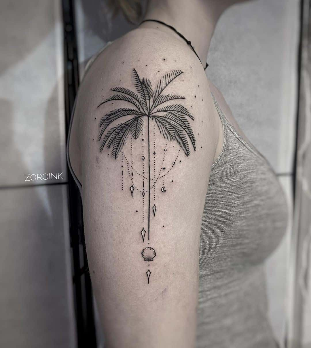 Full view of a lady rocking the shoulder palm tree tats