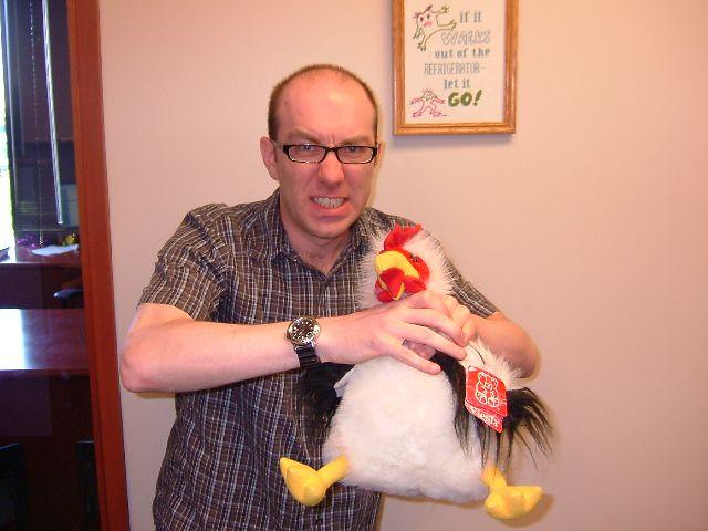 Man choking a chicken stuffed animal.