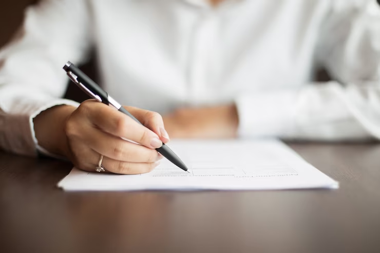 A woman sitting at a desk, working on her medical school personal statement.