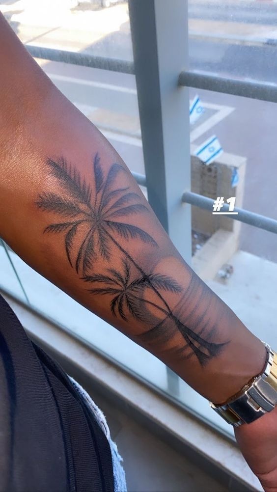 Full view of a palm tree tattoo on the arms of a a guy 