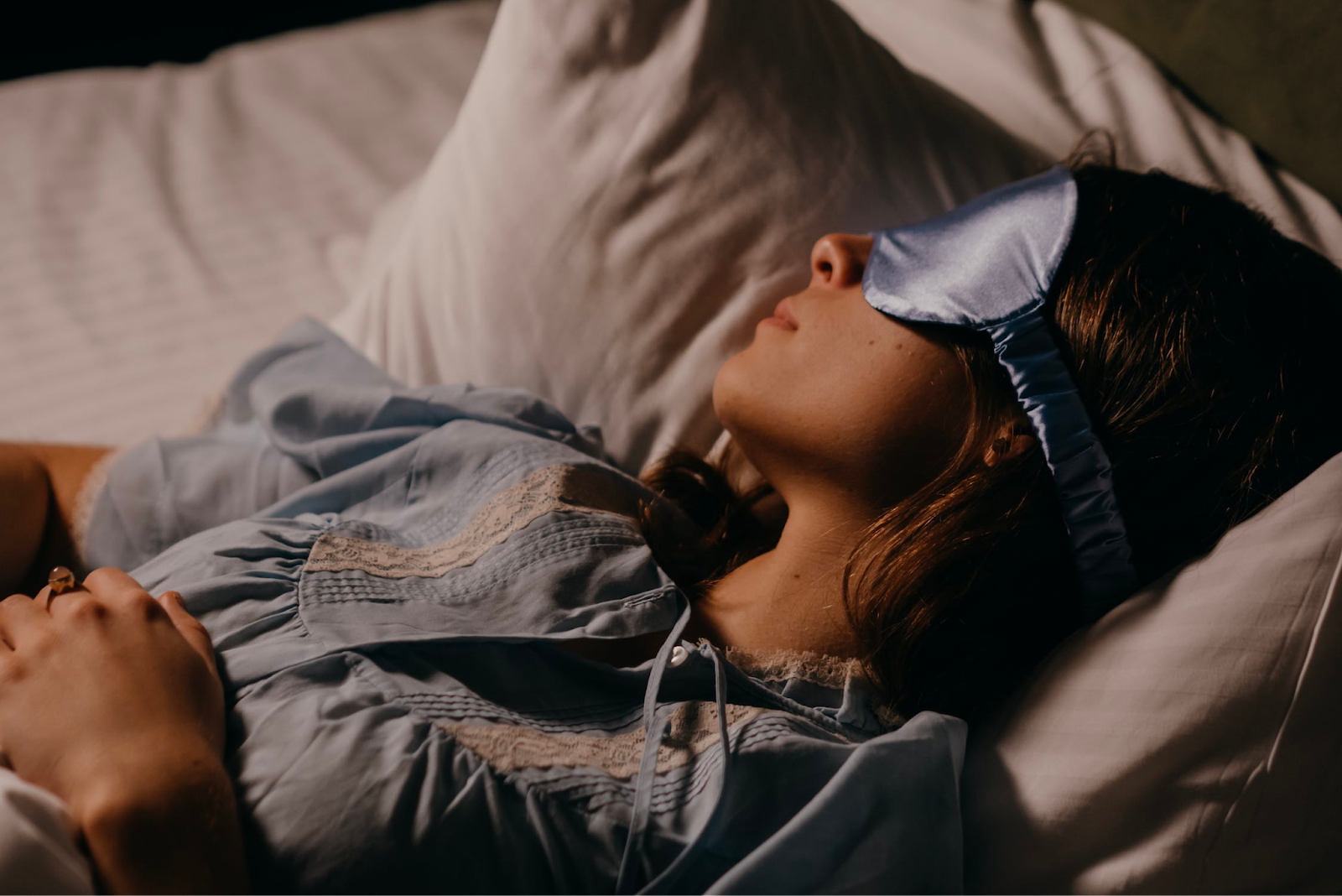 a woman sleeping with a satin sleep mask