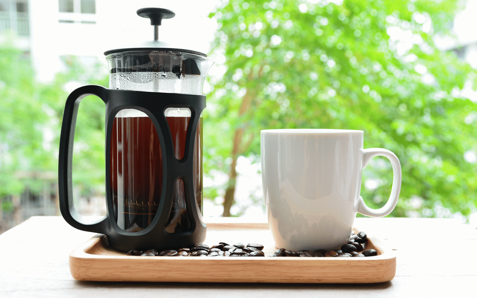 A coffee maker and a mug on a trayDescription automatically generated