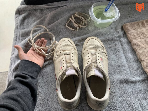 Tháo dây giày và miếng lót trước khi giặt