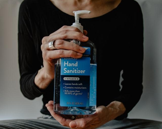 a person holding a hand sanitizer while moving your business in the wake of the global pandemic