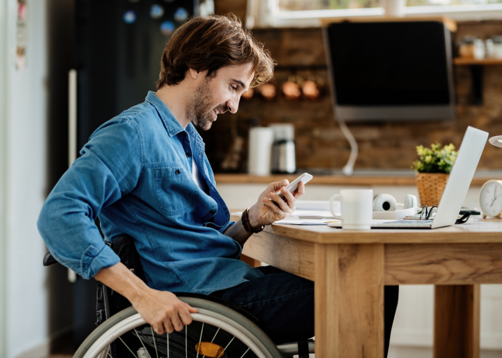 Entrepreneur in wheelchair reading message on smart phone