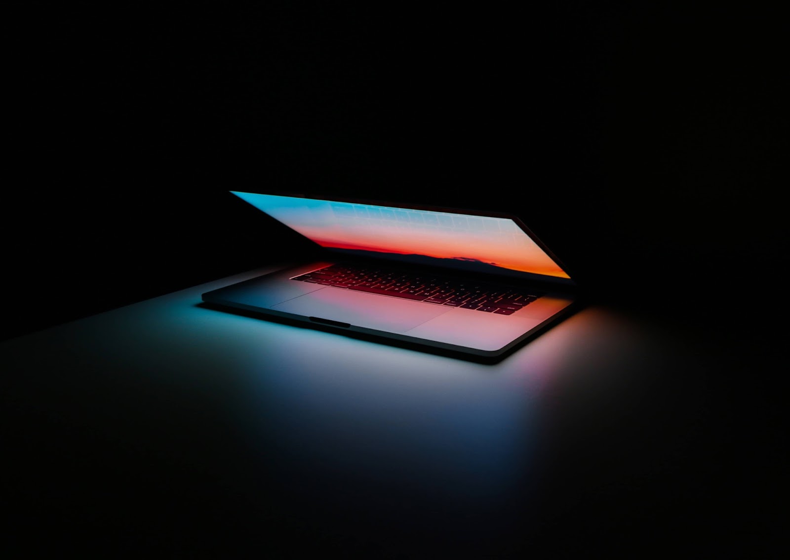 Foto di un computer grigio in accensione appoggiato su una superficie nera