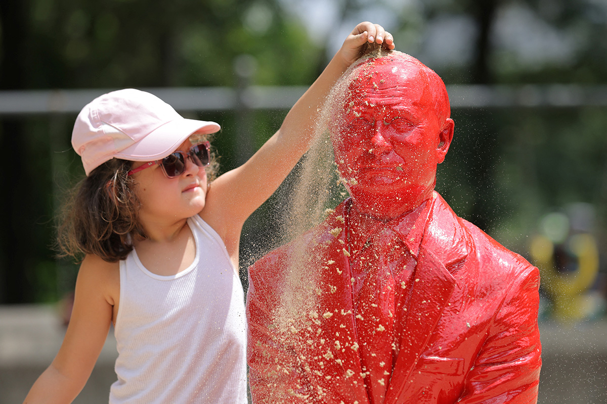 Возможно, девочка начинает закапывать скульптуру президента России, Нью-Йорк, 2 августа 2022 года. Фото: Reuters