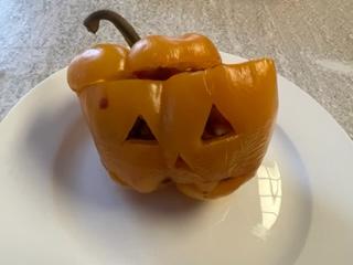 A carved pumpkin on a white surface

Description automatically generated with medium confidence