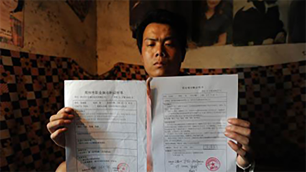 河南新密农民工张海超2009年7月展示两份结论不同的诊断证明书（网络图片）