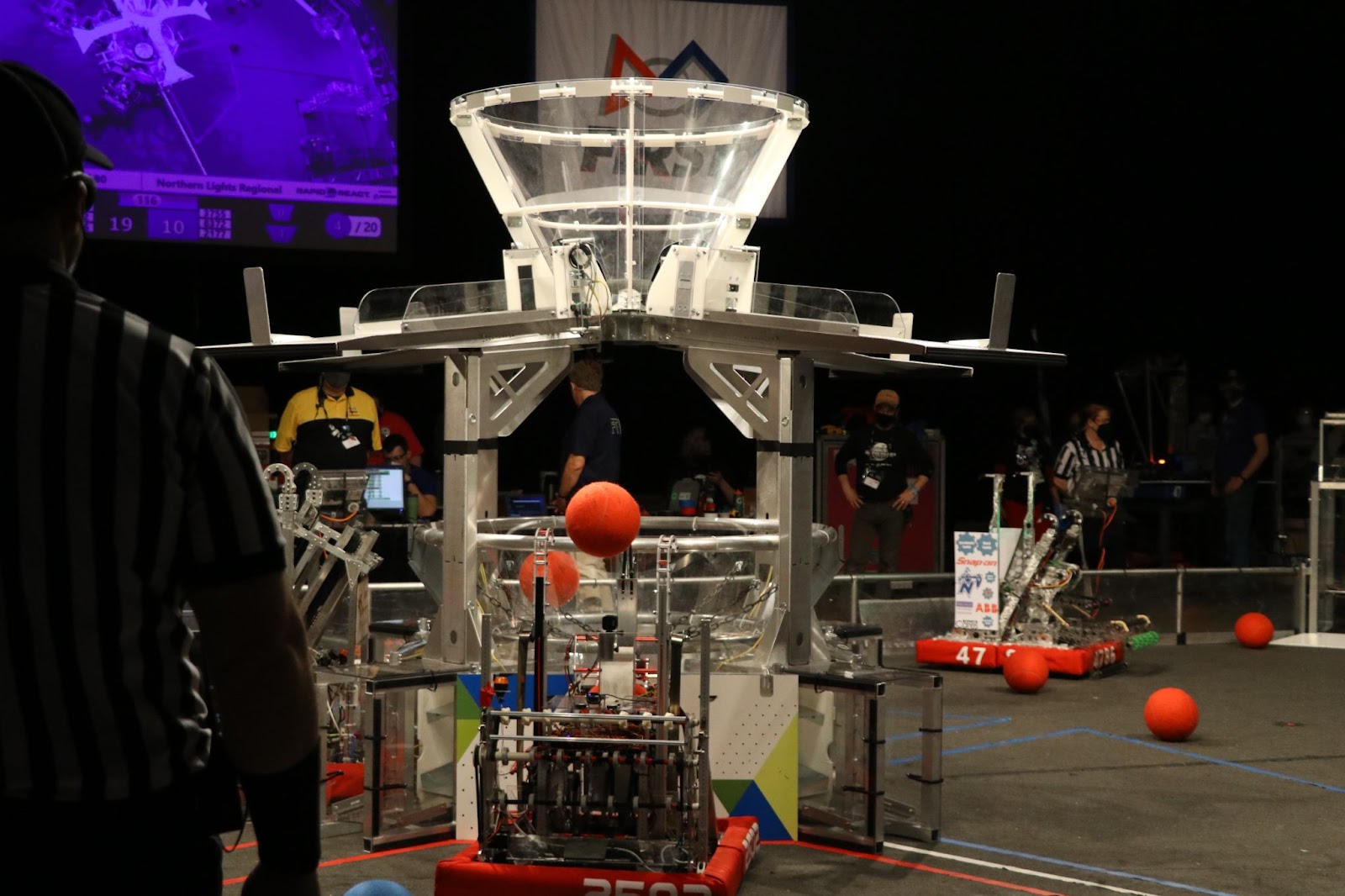 The robot shooting a ball into the lower funnel.